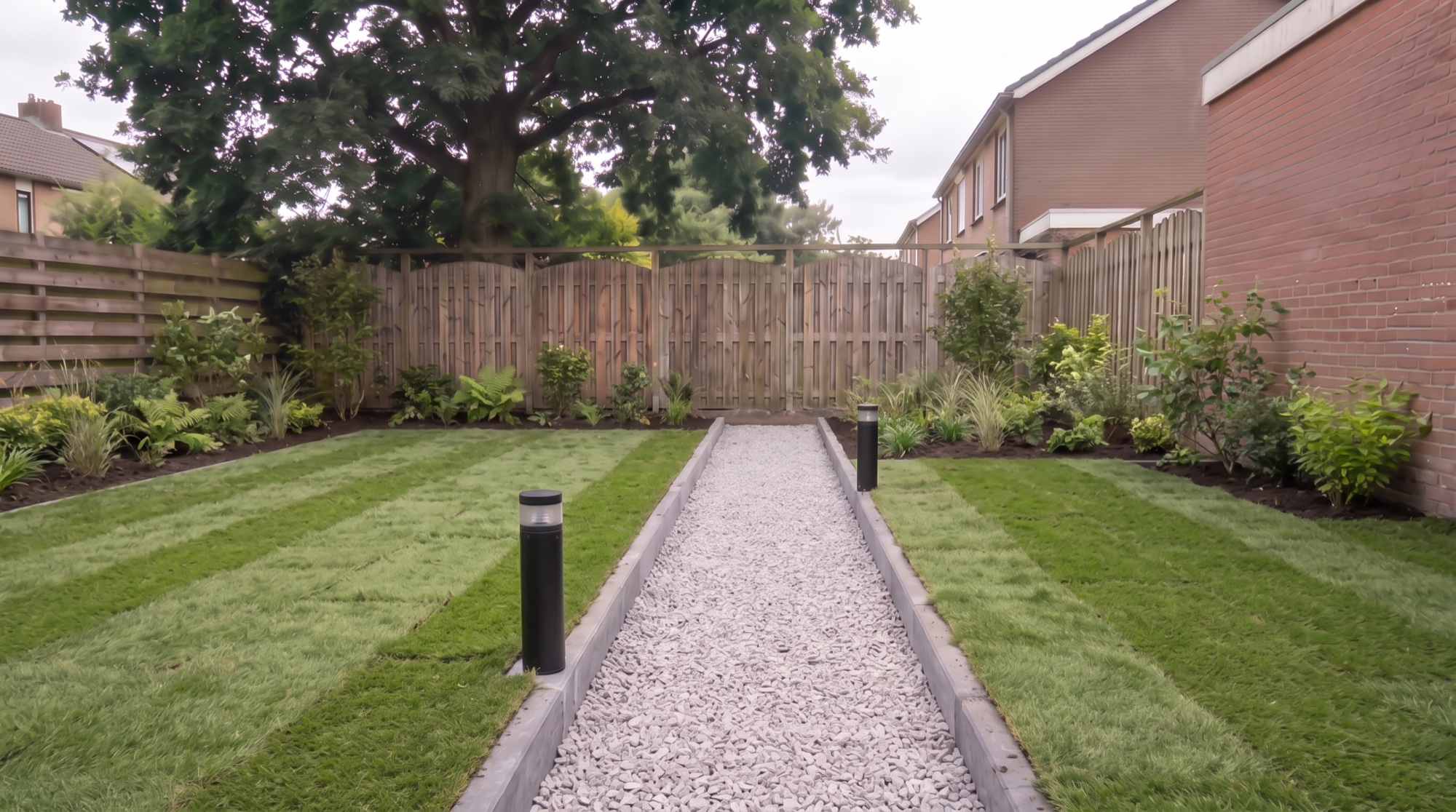 Planted borders framing a new lawn that still shows its seams